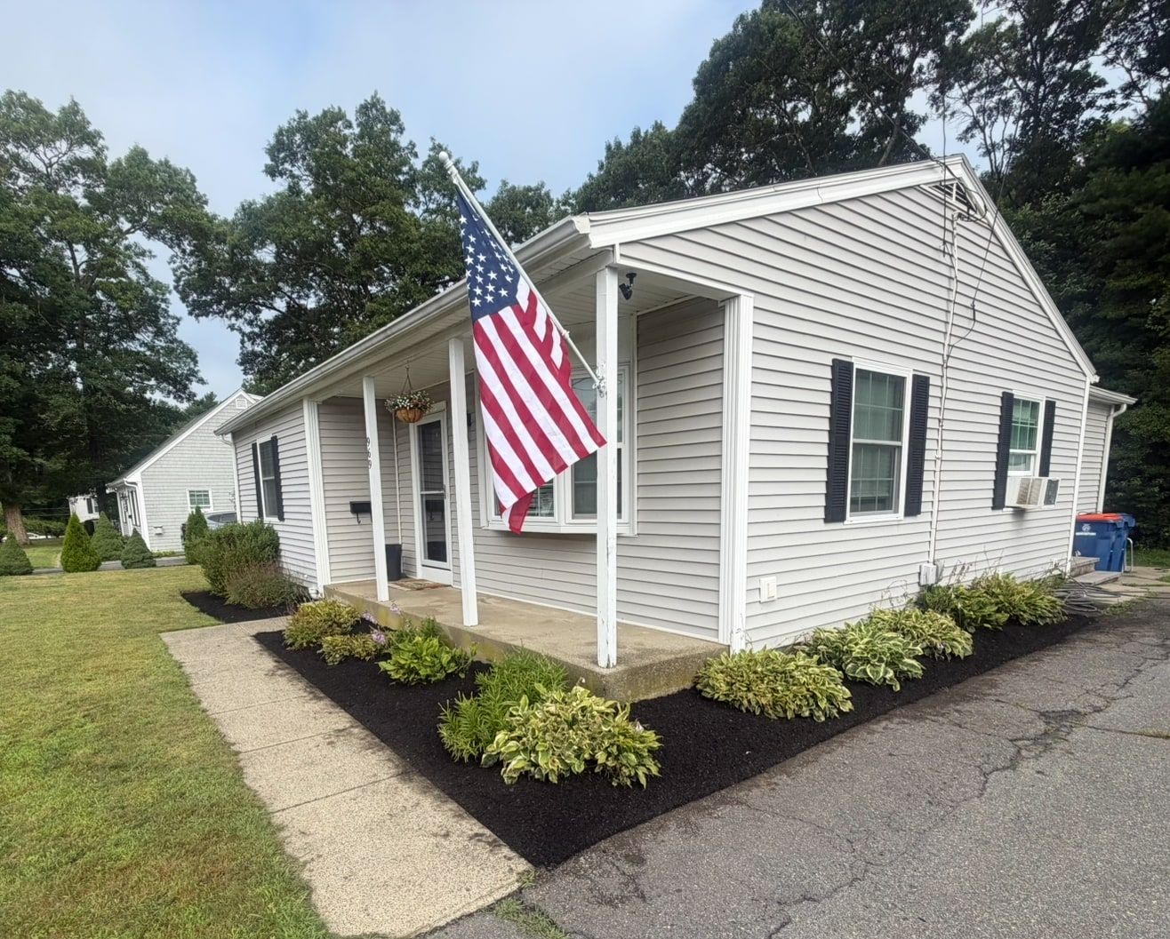 Ranch house with freshly mulched front beds and hostas planted along the porch and walkway