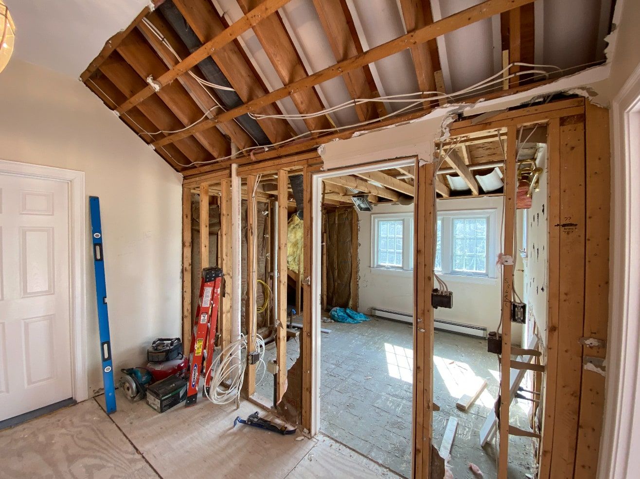 Interior wall opened down to the studs and ceiling joists, with new framing and wiring in progress